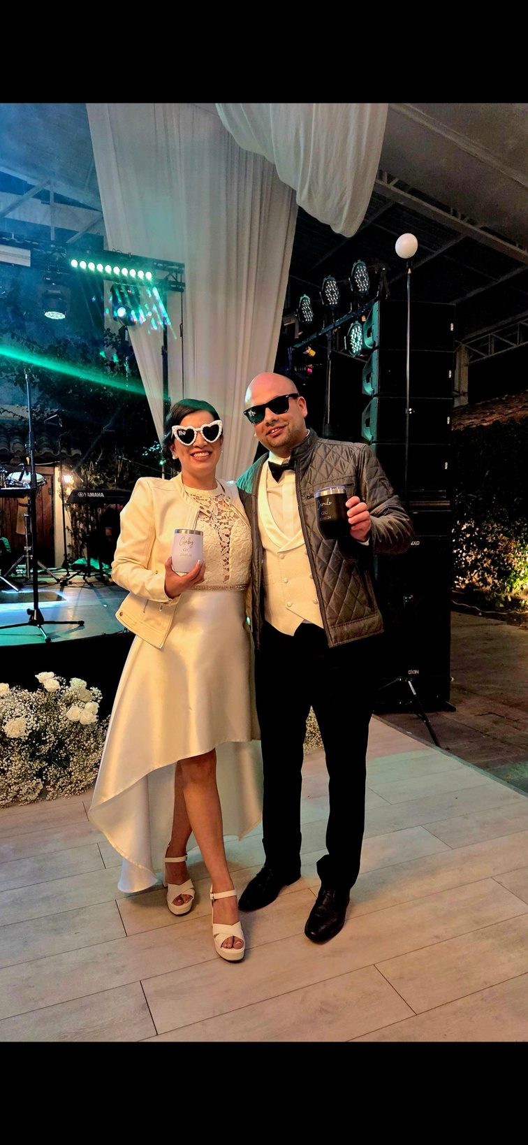 Novios sosteniendo sus jarritos personalizados en la fiesta